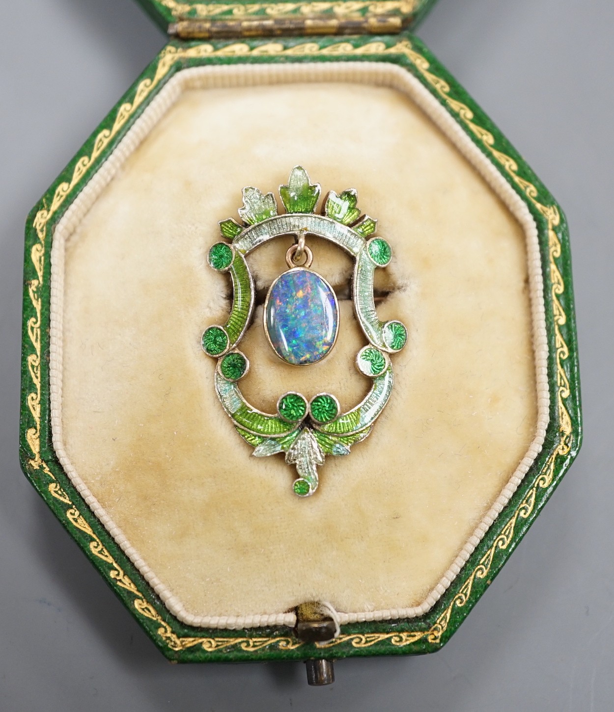 A late Victorian Child & Child yellow metal, green enamel and drop black opal set brooch, 35mm, gross weight 6.4 grams, in fitted Child & Child gilt tooled leather case.